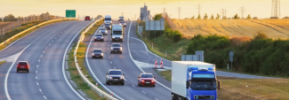 Fleet vehicles driving down highway at sunset